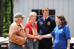 Jacy Darby receives the High Point Individual Winner award and scholarship at 2015 State Wood Clinic held April 22, 2015 at Stephen F. Austin Experimental Forest. Betty Zimmerman Chair of the TFA's Forest Landowner's Council, far right, presented the plaque and $1,000 scholarship to the Big Sandy ISD senior.
